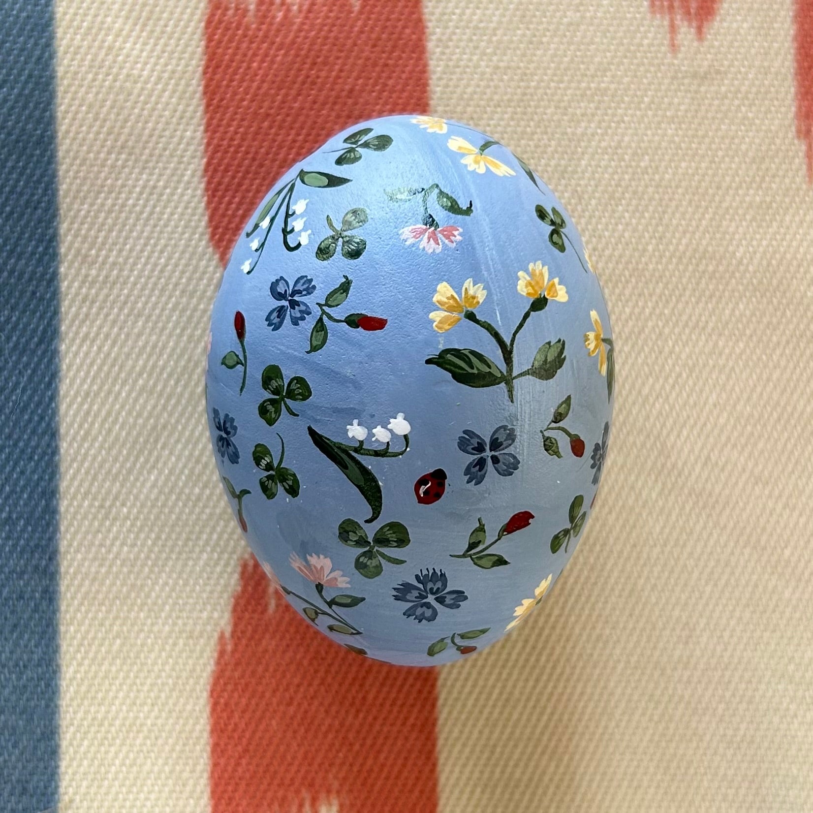 Flowers, Ladybugs, and Clovers on Blue Egg